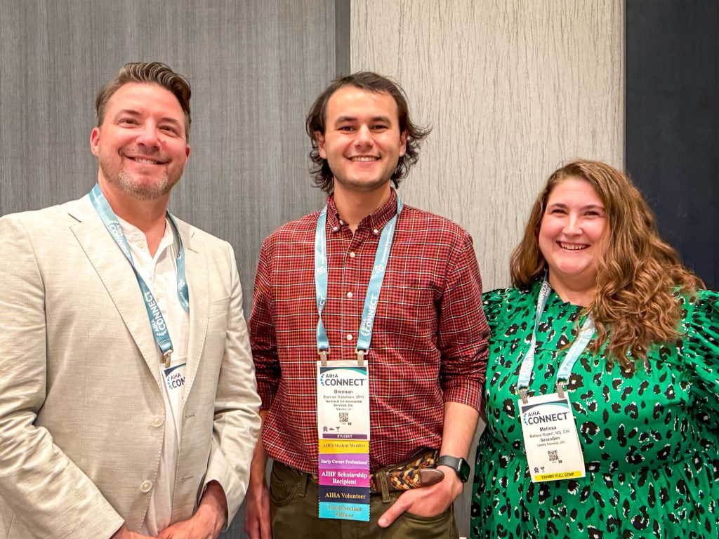 Scholarship recipient smiling while standing with two peers.
